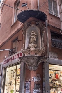 Sculpture of the Virgin Mary with canopy on a corner house in the historic centre, Genoa, Italy,