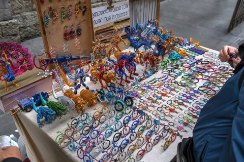 Table with colourful wire figures of a street vendor, old town in Genoa, Italy, Europe