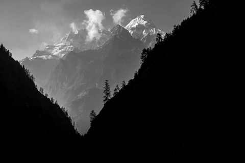 Lapuchung (5969 m) peak, with silhouettes of some trees in the foreground, seen from the way