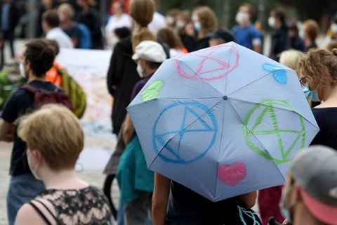 Demonstrators with umbrella with logos of the group Extinction Rebellion at the alliance demo on