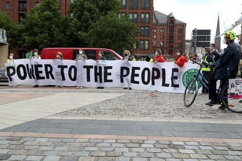 Demonstrators hold a banner with the inscription Power to the people at the alliance demo on