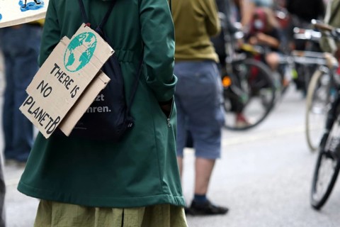 Demonstrator with sign saying There is no planet B at the alliance demo on climate racism and