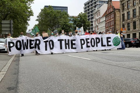 Demonstrators hold a banner with the inscription Power to the people at the alliance demo on