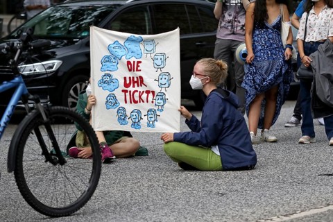 Demonstrators hold a banner with the inscription The clock is ticking! at the alliance demo on