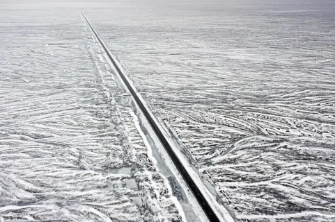 Aerial view over Route 1, Ring Road, two-lane national road in desolate snow covered winter