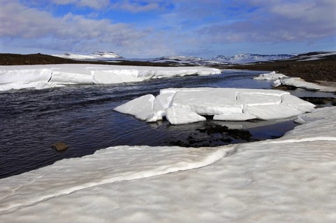 Spring melt in the Miohusaa river above the town of Egilstadir, with a distant view of the