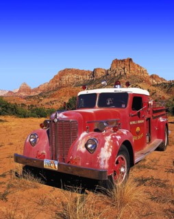 Old-style red fire engine parked on scrubland at the entrance to Zion Canyon, Utah, USA Oldtimer,