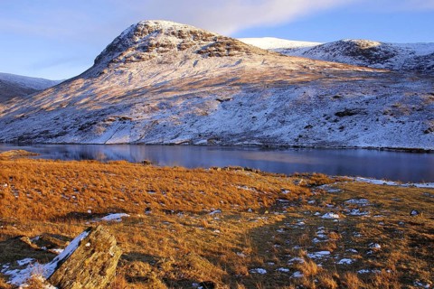 Snow-covered hills and Loch Stronuich under a blue sky in upper Glen Lyon, Perthshire, Scotland,