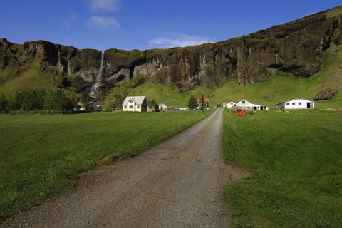 Farming township nestles beneath basalt crags at Foss, southern Iceland