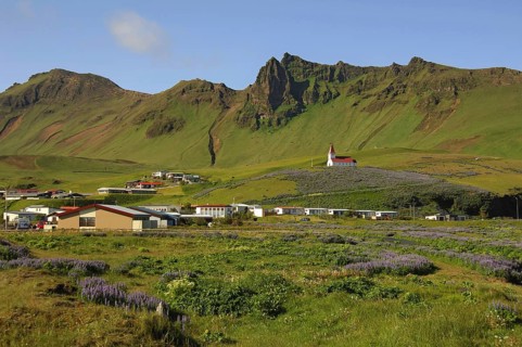 The town of Vik, southern Iceland, with its church above, all beneath crags and steep hillsides