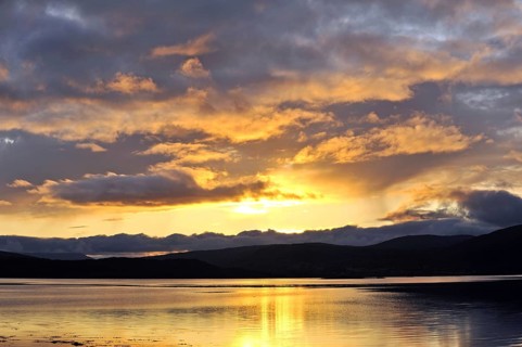 Vivid sunset light reflects across the inner fjord near Ostervik, north-west Norway