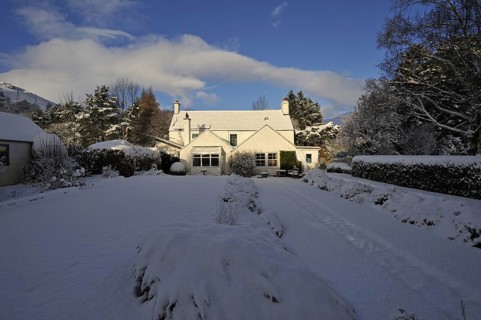 Snow-covered trees in a country house and garden in winter, Killin, Perthshire, Scotland, UK