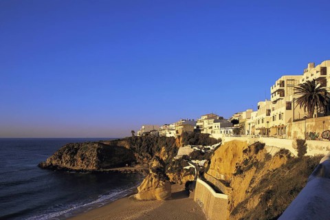 Apartments in early morning light under a deep blue sky overlook the deserted west end of the main