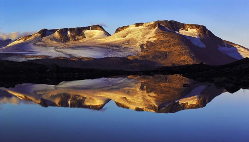 Early-morning light on the Fannaraken peaks with a mirror-like reflection in a glacial lake,