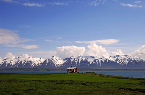 Wooden cabin on the shores of Eyjafjordur with the Kaldbakur mountains behind, near Dalvik,