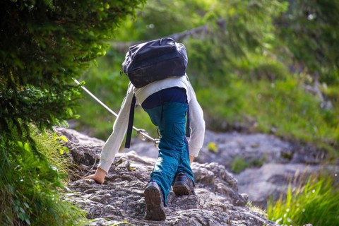 Hiking in the Allgaeu Alps: Boy on a passage secured with a wire rope on the ascent from the