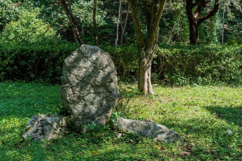 Large boulder between two smaller boulders in shaded mountainside park in South Korea
