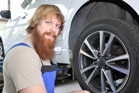 Symbolic image: Car workshop: Car mechatronics technician servicing tyres