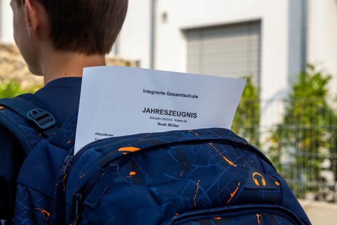 Symbolic image of report cards: Pupils at an integrated comprehensive school on their way home with