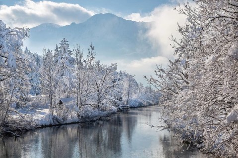 Winter landscape with outflow of the Loisach from the Lake Kochel in front of the Herzogstand
