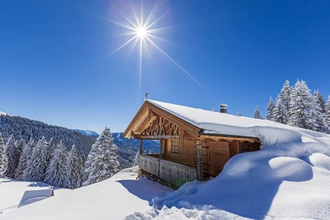 Alpine hut in winter with sun, snow, sunbeams, Hoernle-Alm, Ammergau Alps, Upper Bavaria, Bavaria,
