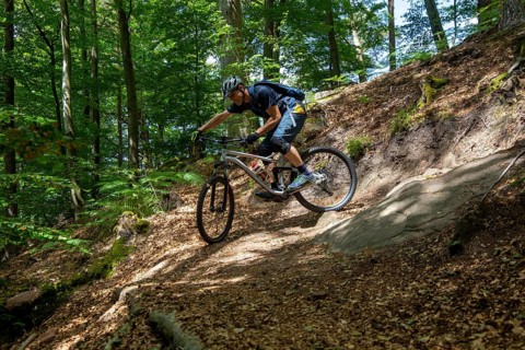 Mountain biker negotiates a tight hairpin bend in the Pfaelzerwald mountain bike park near Dahn