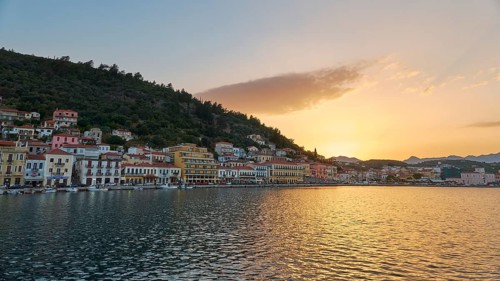 Town view at dusk with houses on the waterfront and mountains in the background, Taygetos