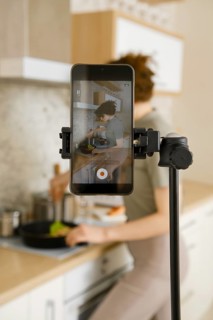 Food vlogger recording video in her kitchen, making step by step tutorial of a receipt