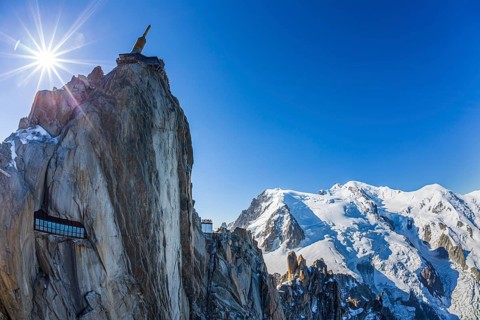 Mountain station and mountain peak with glacier in sunlight, backlight, fisheye, view of Aiguille