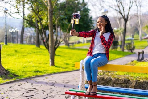 Horizontal photo with copy space of a happy african woman blogger is filming video blog on the