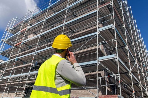 Symbolic image: Architect in front of an apartment block under construction