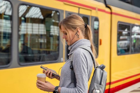 Close-up of a young woman in front of a train at the station