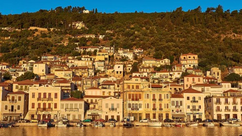 The morning light illuminates the lively coastal panorama and the busy harbour, Gythio, Mani,