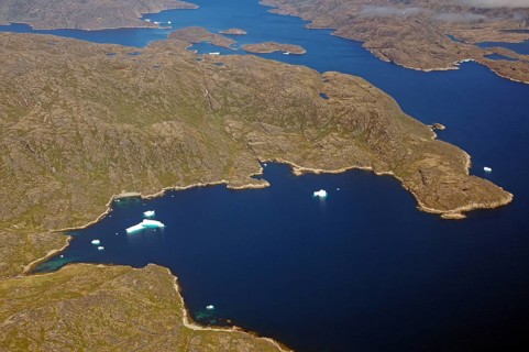 Iceberg, ice and islands, in a fjord, aerial view, rough, snow-covered rough mountain landscape,