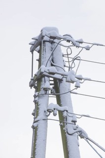 Old, snow-covered telegraph pole in winter, Germany, Europe