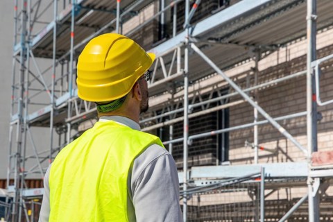 Symbolic image: Architect in front of an apartment block under construction