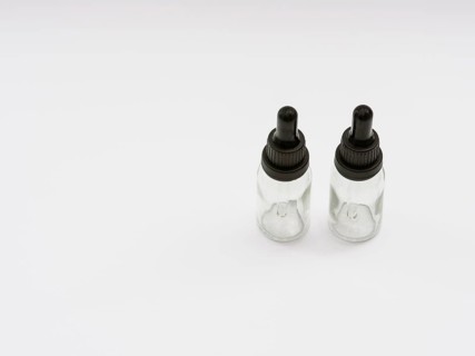 Two glass eye dropper bottles isolated on white background