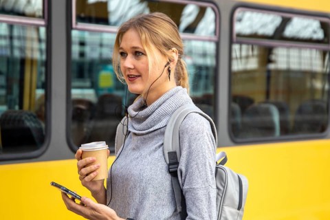 Close-up of a young woman in front of a train at the station