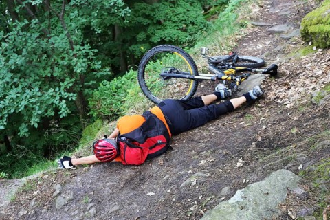 Injured mountain biker lying on the ground in an accident