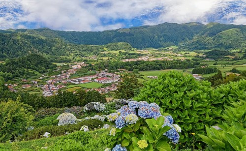 View of the Furnas valley surrounded by lush vegetation and colourful hydrangeas under a cloudy