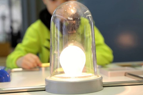 Child conducting a physics experiment with a simple circuit
