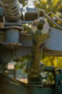 Closeup of machine gun muzzle with barrel, turret and mount blurred out in background