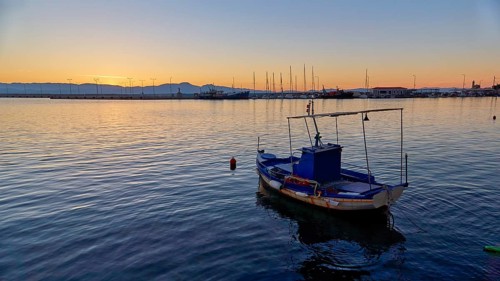 Lonely boat on the sea during a calm sunset, Gythio, Mani, Peloponnese, Greece, Europe