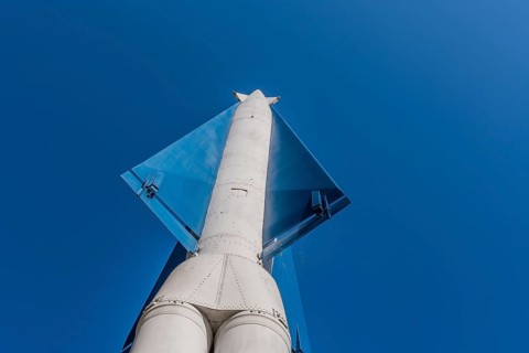 Vertical view of surface to air missile pointing toward blue sky in background