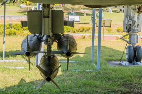 Rear view of battery of missiles mounted under wing of military jet aircraft on display in public