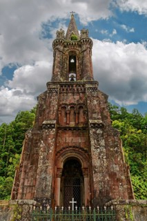 Close-up of an old Gothic church tower of Capela de Nossa Senhora das Vitorias with a cross against