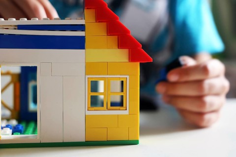 Boy builds a house with building blocks