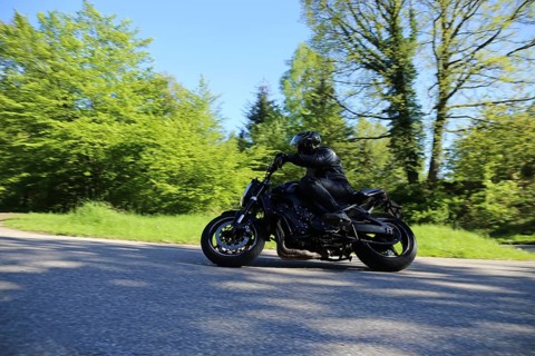 Sporty motorcyclist on a sporty ride on a country road in the forest