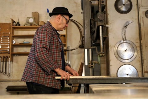 Furniture restorer works with a jigsaw