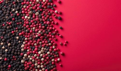 Top view of pink and black pepper peppercorns on pink background AI generated